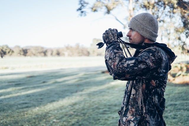 A hunter in camouflage looks for a turkey in the woods during turkey season