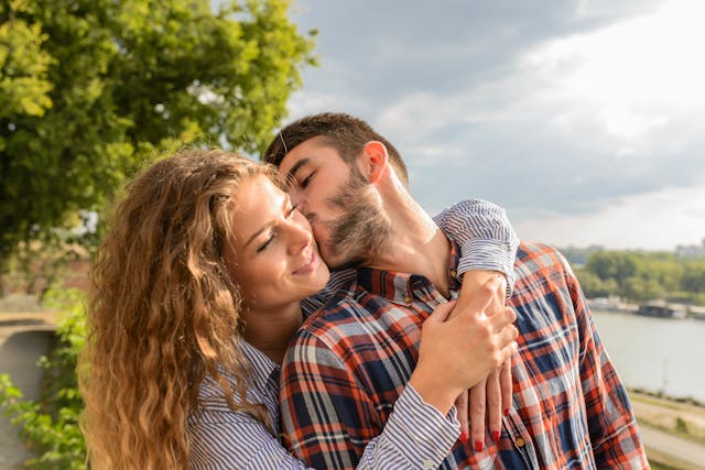 A couple embracing by a river